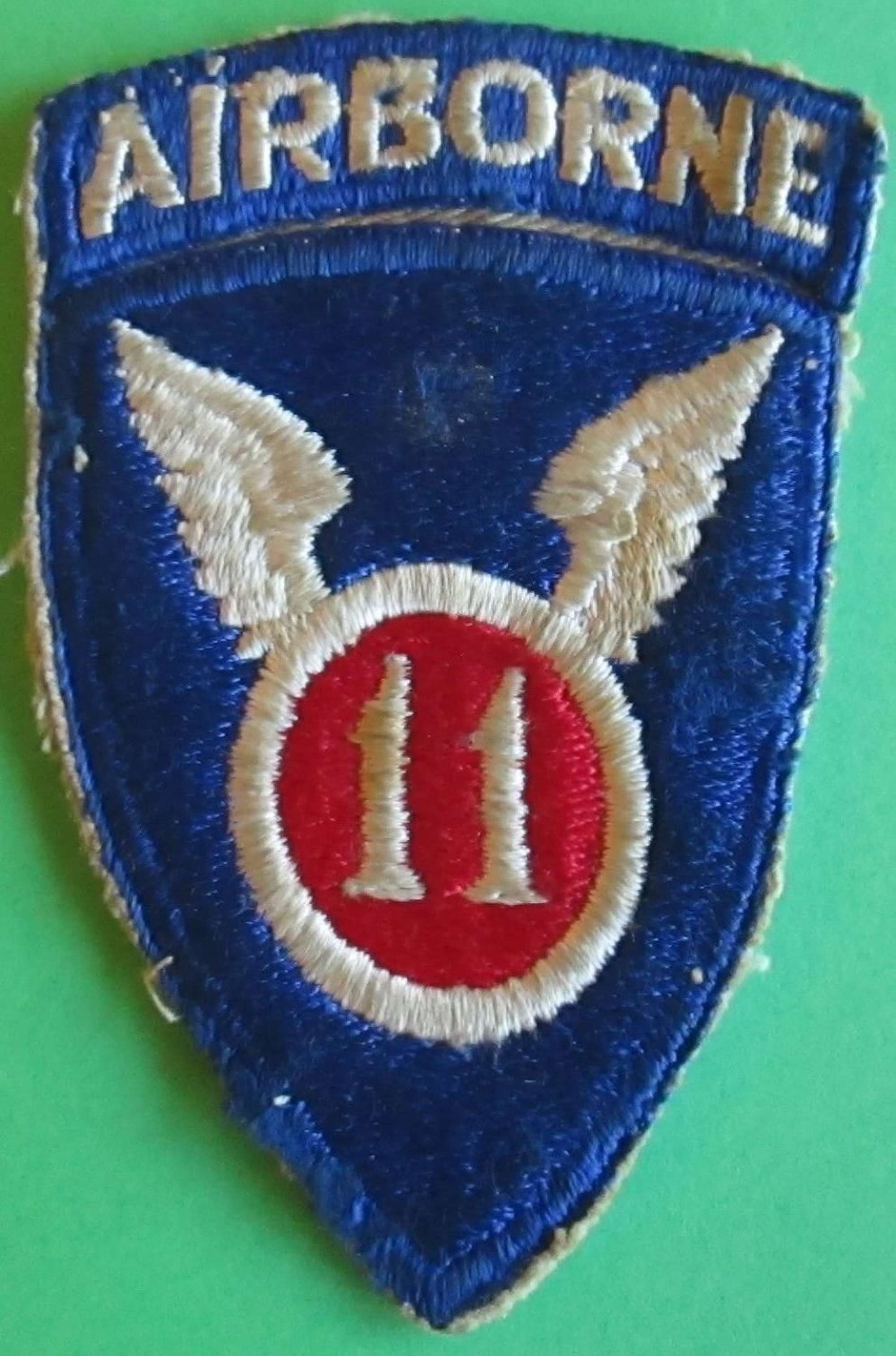 A 1 PIECE CONSTRUCTED US 11TH AIRBORNE FORCE ARM BADGE