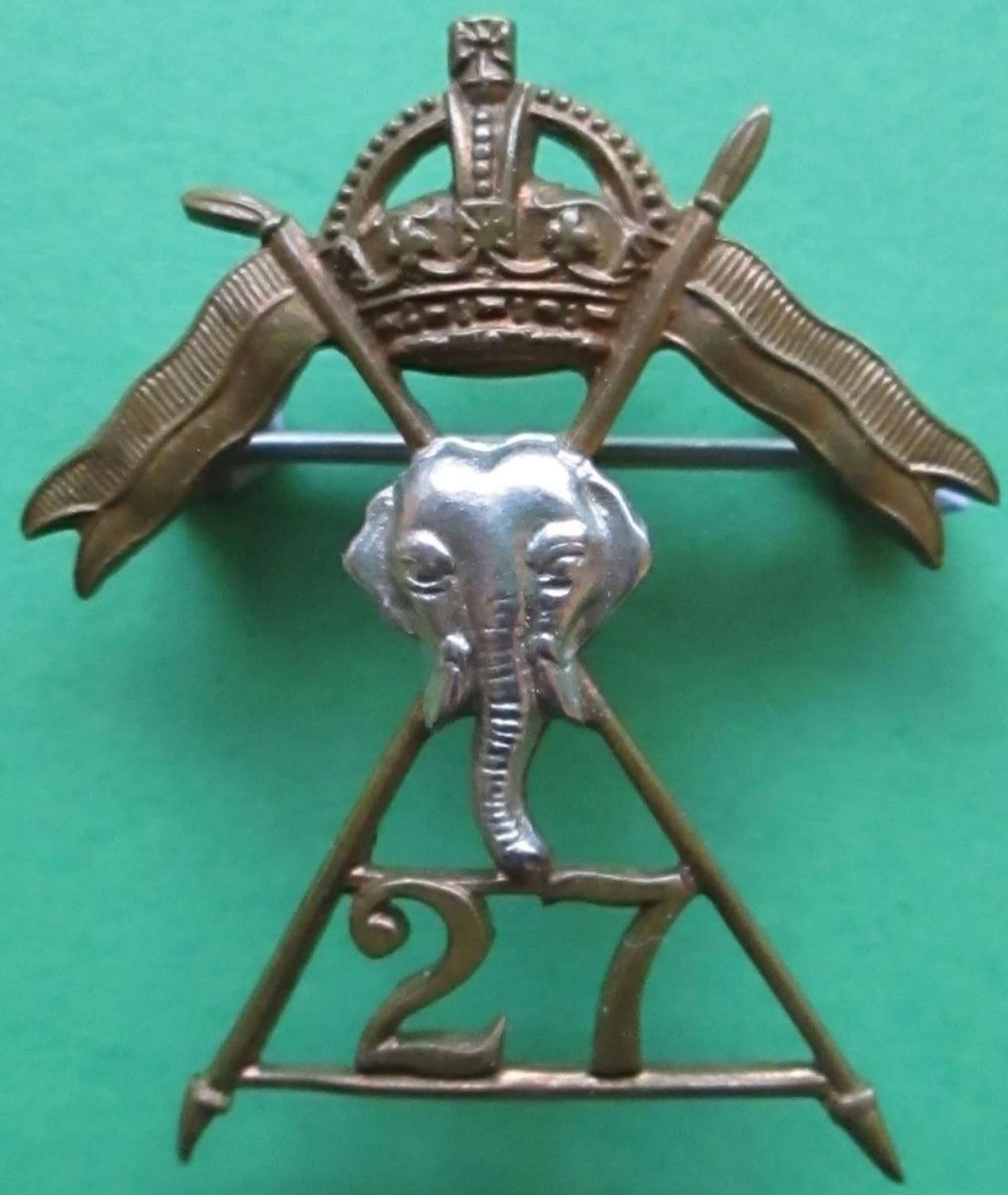 A 27th LANCERS CAP BADGE WHICH HAS BEEN BROOCHED