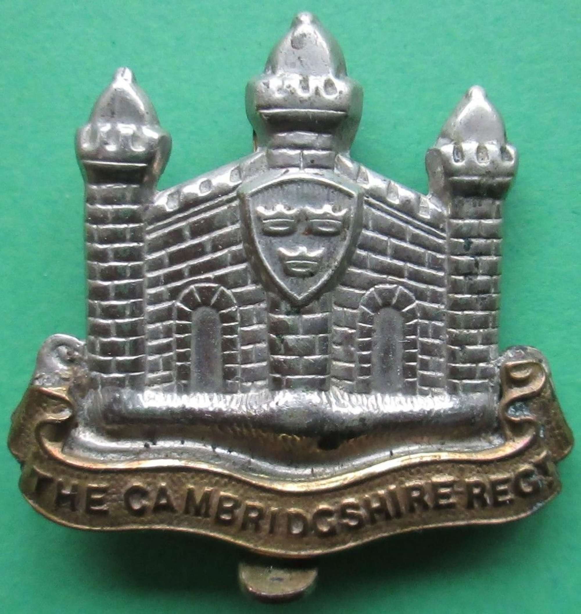 A CAMBRIDGESHIRE REGT CAP BADGE WITH THE 1ST E MISSING