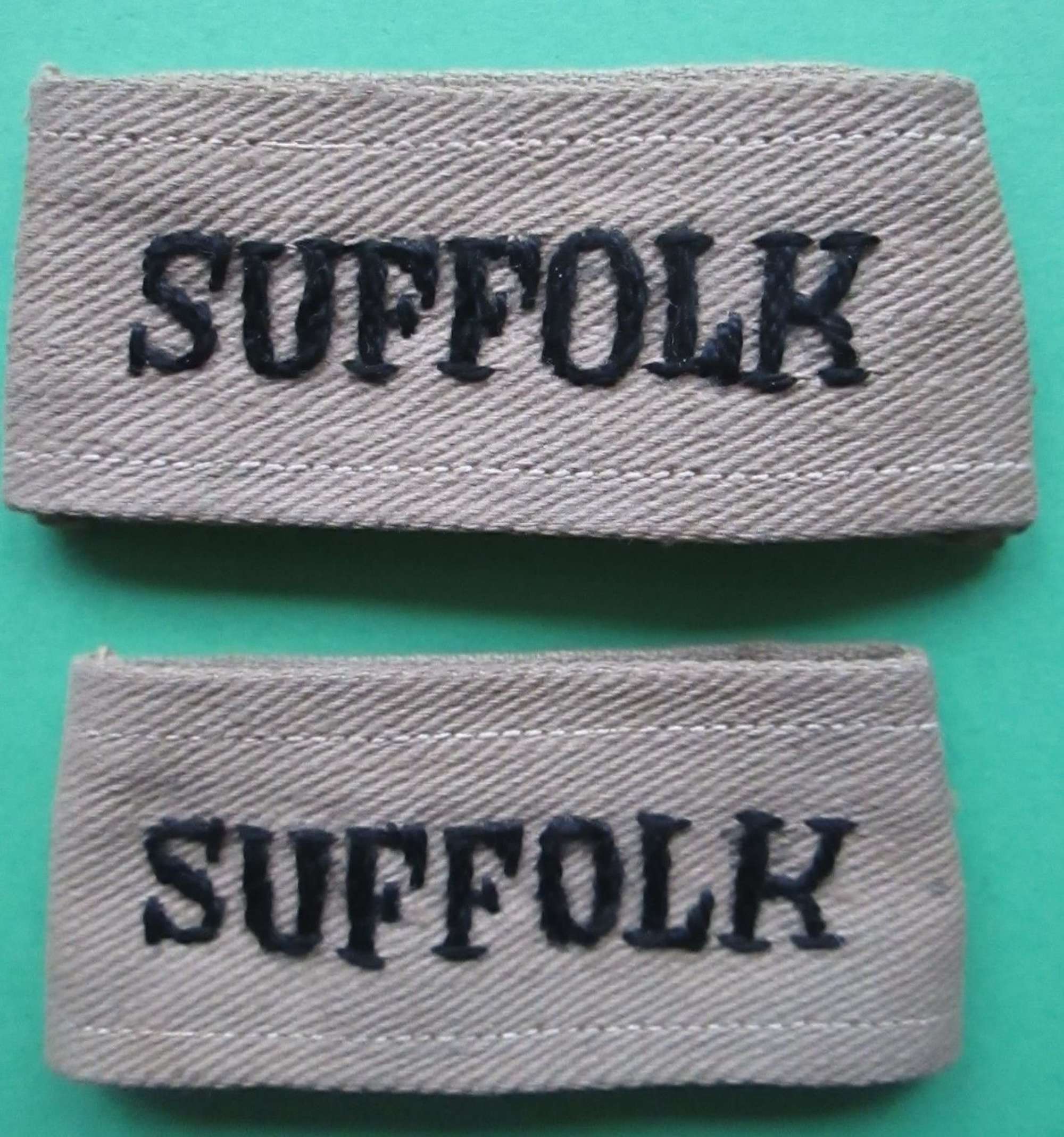 A MATCHING PAIR OF THE TROPICAL SUFFOLK REGT SLIDE ON TITLES