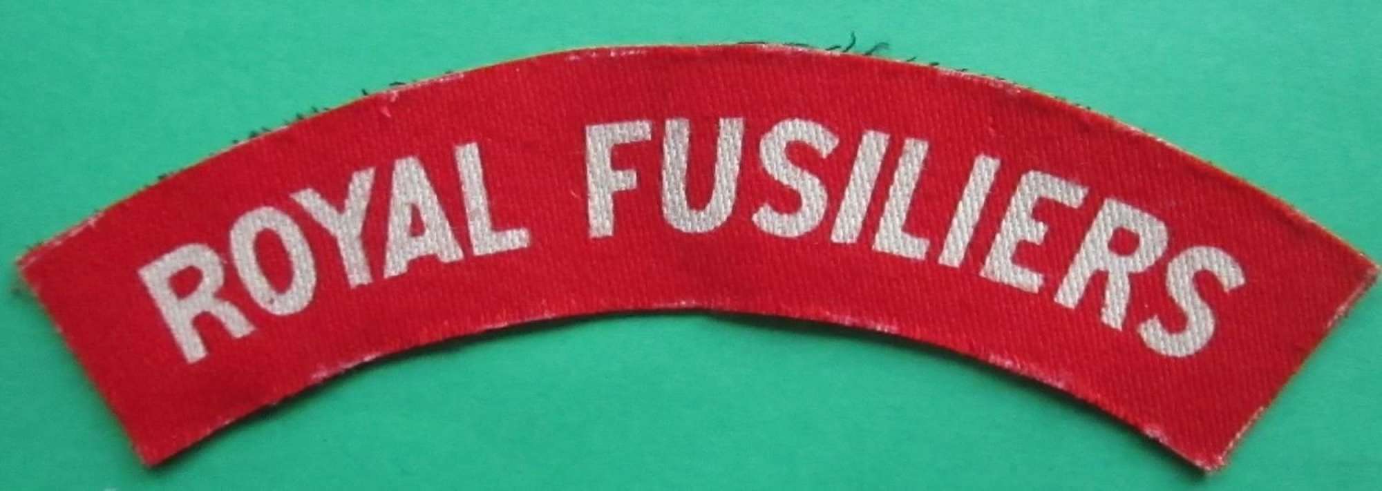 A PRINTED ROYAL FUSILIERS SHOULDER TITLE