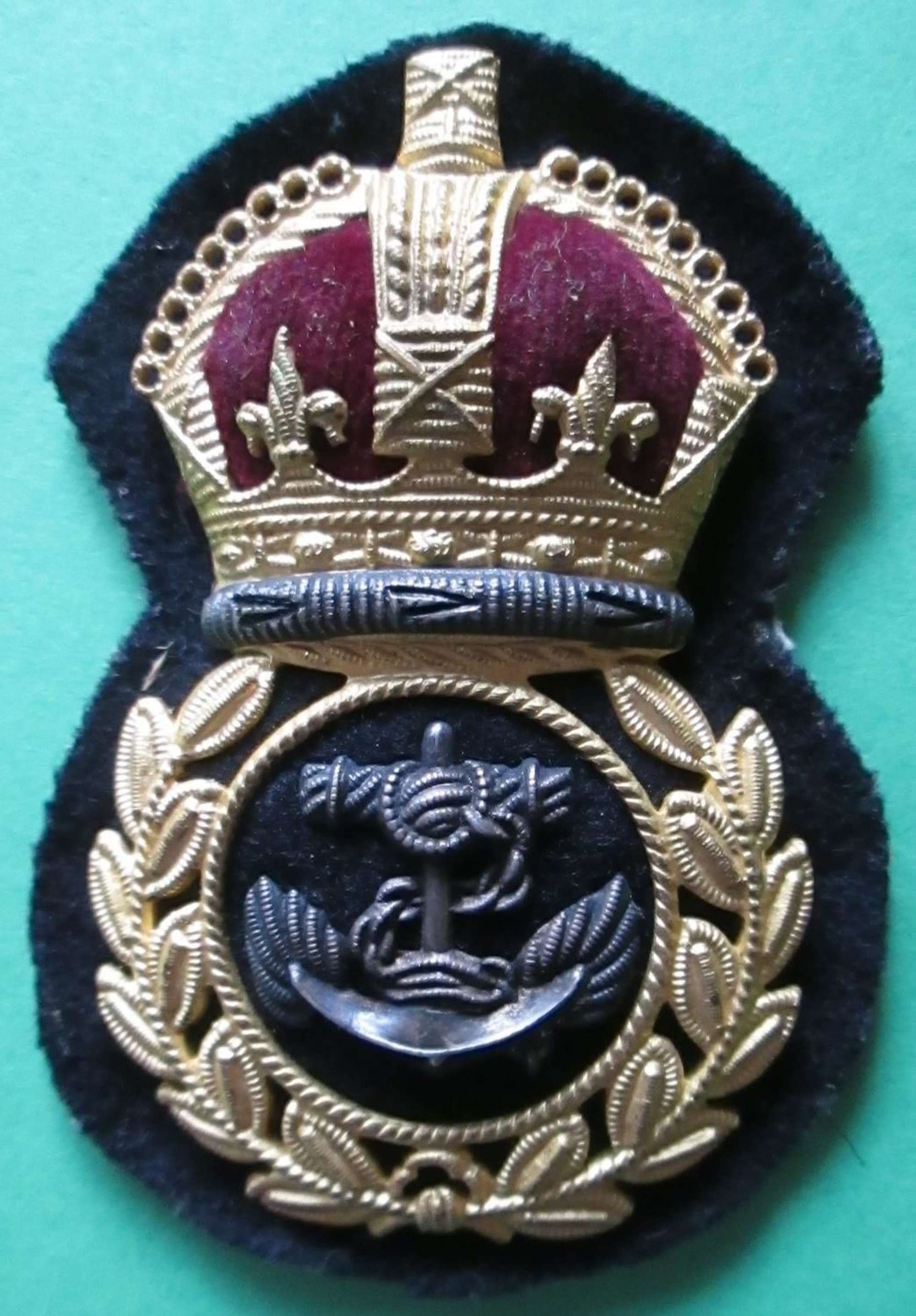 A WWII ECONOMY CHIEF PETTY OFFICERS GILT AND SILVER CAP BADGE
