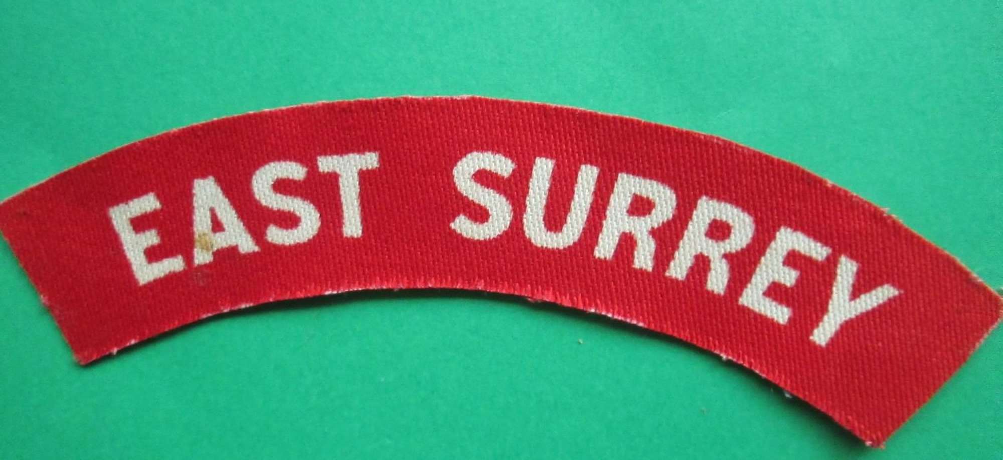 A WWII PRINTED EAST SURREY'S SHOULDER TITLE