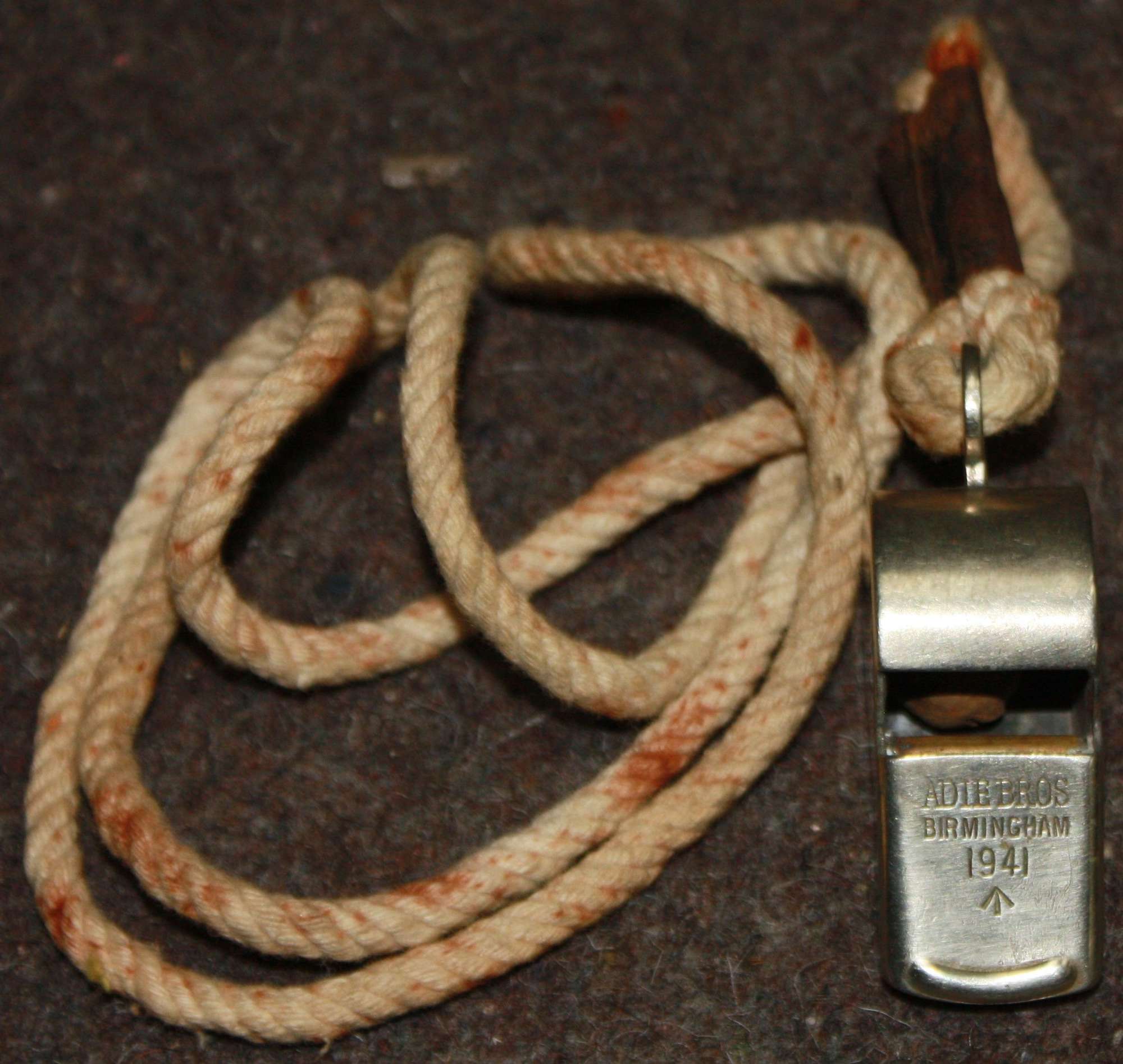 A 1941 DATED SNAIL WHISTLE WITH ITS FITTED NECK CORD