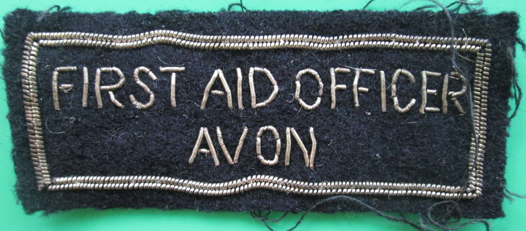 A CIVIL DEFENCE ARM BADGE FOR A FIRST AID OFFICER IN AVON