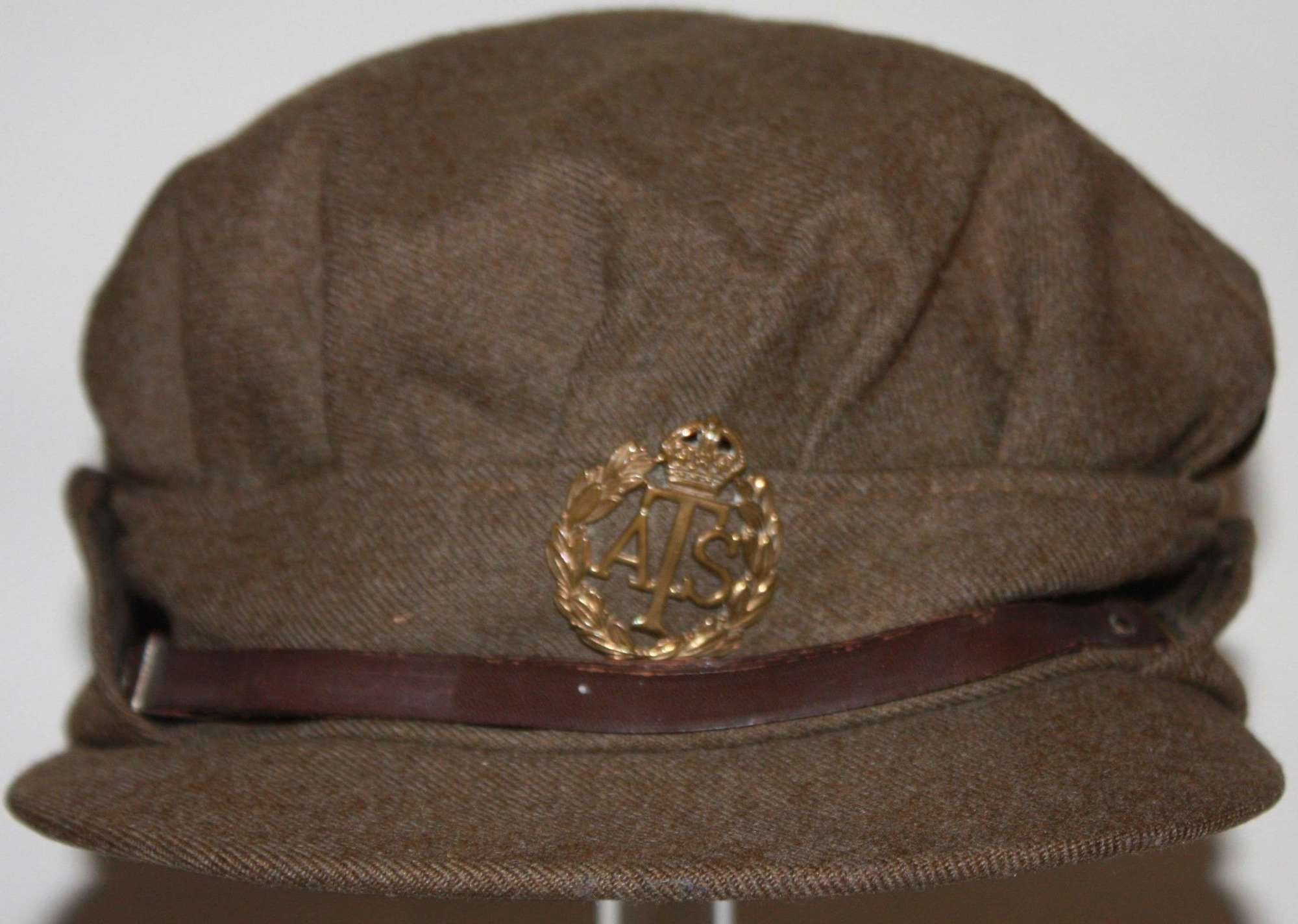 A GOOD USED WWII ATS PEAKED CAP 1942 DATED EXAMPLE SOME REPIARS TO IT
