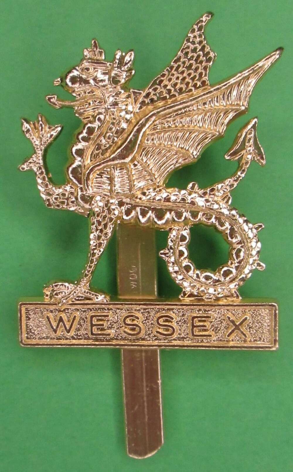 A WESSEX BRIGADE GOLD COLOURED ANODISED ALLOY CAP BADGE